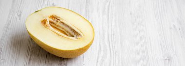 Beyaz ahşap arka plan, yan görünüm kavun yarısı. Kopya alanı.