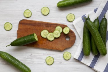 Taze çiğ yeşil salatalık, yukarıdan görünüm. Düz yatıyordu, genel gider, en iyi görünüm. Beyaz ahşap zemin.