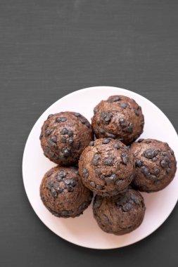 Siyah arka plan, havai görünümü üzerine pembe plaka üzerinde çikolata cupcakes. Yukarıdan Lay, düz. Kopya alanı.