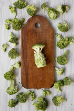 Taze çiğ brokoli rustik ahşap tahta üzerinde beyaz ahşap arka plan, yukarıdan kesti. Yukarıdan, ek yük düz lay.