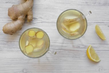 Ev yapımı iki bardağı beyaz ahşap arka planda, havai görünümü limonlu çay zencefil. Yukarıdan, üstten görünüm düz lay.