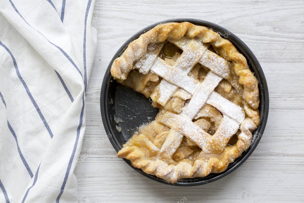 Home-baked apple pie on white wooden surface, top view. Flat lay, overhead, from above. Closeup.