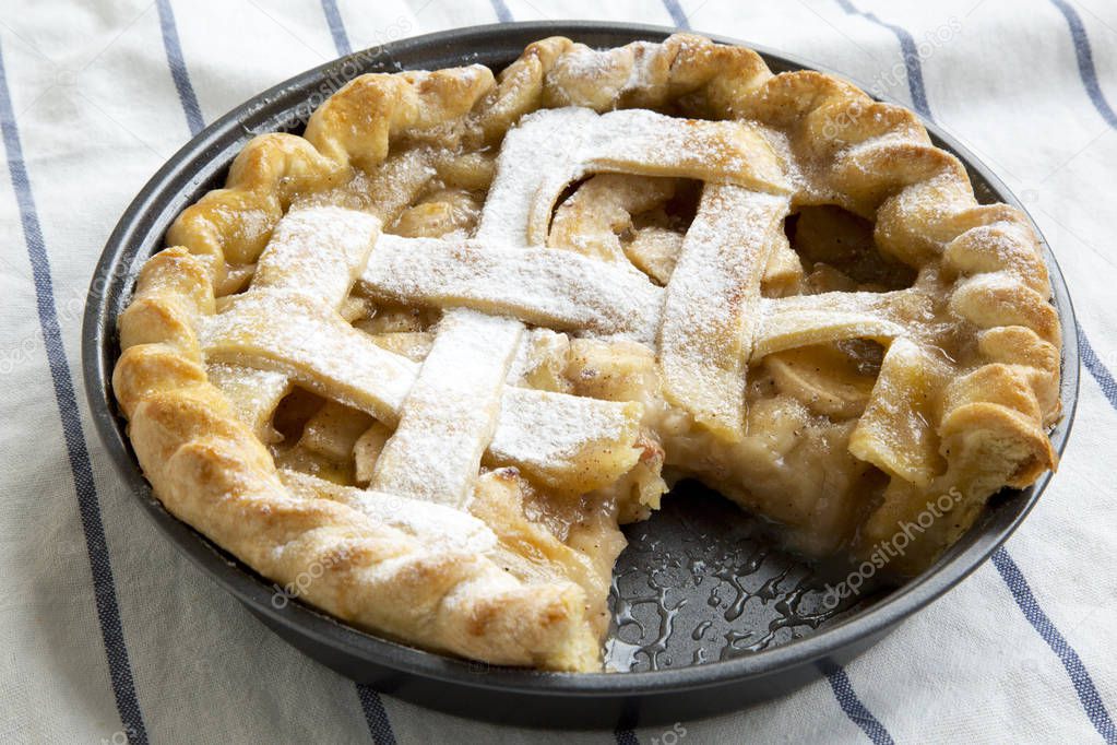 Home-baked apple pie on cloth, side view. Close-up.