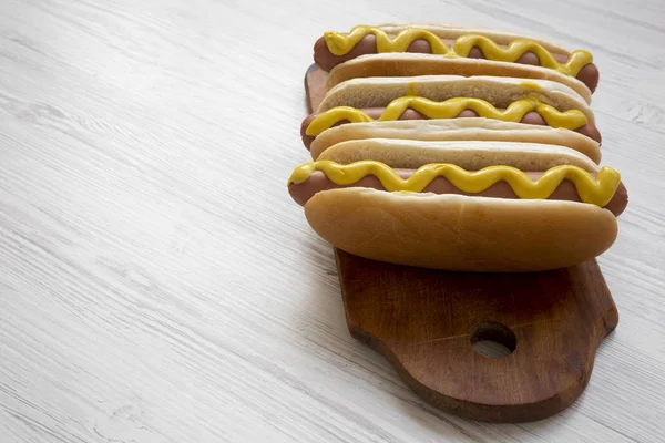 Hot Dog Κίτρινο Μουστάρδα Ξύλινη Σανίδα Άσπρο Φόντο Ξύλινη Πλάγια — Φωτογραφία Αρχείου