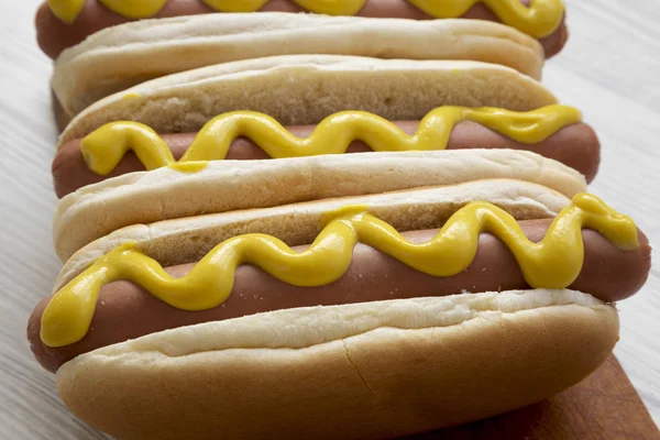 Hot Dog Κίτρινο Μουστάρδα Ξύλινη Σανίδα Άσπρο Φόντο Ξύλινη Πλάγια — Φωτογραφία Αρχείου