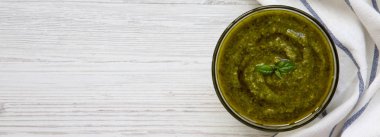 Fesleğen pesto havai görünümü Beyaz ahşap yüzeyde. Metin için yer.
