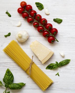 Bir beyaz tahta yüzeyi, havai görünümü makarna yemek pişirmek için farklı malzemeler. Düz yatıyordu. Üstten görünüm. 