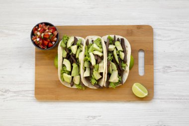 Mısır ekmeği ızgara sığır eti, avokado, kireç ve salsa Bambu tahta, üstten görünüm üzerinde. Yukarıda, ek yükü.