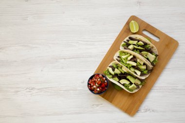 Mısır ekmeği ızgara sığır eti, avokado, kireç ve salsa Bambu tahta, üstten görünüm üzerinde. Düz, tepegöz, yukarıdan yatıyordu. Kopya alanı.