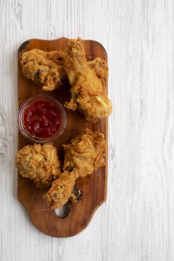 Beyaz ahşap yüzey, havai görünümü üzerinde ahşap tahta üzerinde soslu kızarmış tavuk budu. Yukarıdan Lay, düz. Metin için yer.
