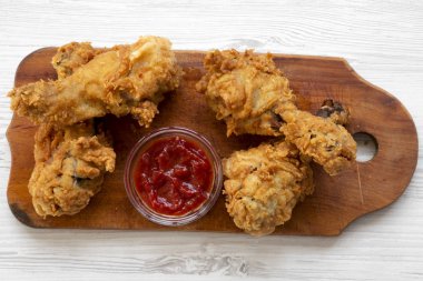 Beyaz ahşap yüzey, havai görünümü üzerinde ahşap tahta üzerinde soslu kızarmış tavuk sopaları. Yukarıdan, üstten görünüm düz lay.