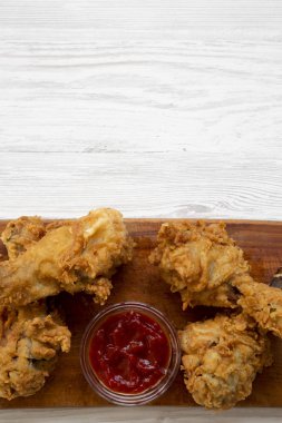 Beyaz ahşap arka plan, üstten görünüm üzerinde ahşap tahta üzerinde soslu kızarmış tavuk sopaları. Yukarıdan Lay, düz. Kopya alanı.