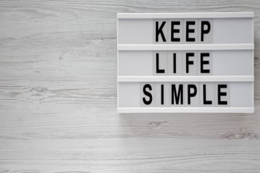 'Hayat basit tutmak' kelimeleri modern beyaz ahşap yüzey, en iyi görünümü kurulu. Yukarıdan Lay, düz. Kopya alanı.