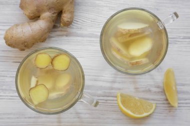 Beyaz ahşap masa, havai görünümü üzerinde limon ile ev yapımı zencefil çayı. Yakın çekim. Yukarıdan, ek yük düz lay.