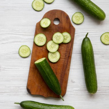 Taze ham organik yeşil salatalık Beyaz ahşap zemin, havai görünümü üzerinde. Yukarıdan, üstten görünüm düz lay. 