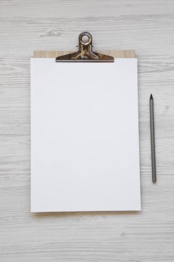 Pano kağıt ve kalem Beyaz ahşap yüzey, en iyi görünümü üzerinde boş levha ile. Düz, tepegöz, yukarıdan yatıyordu.