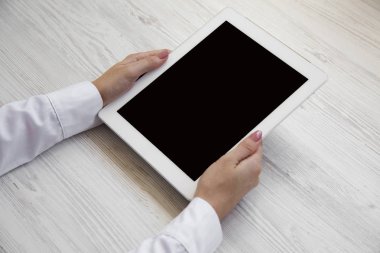 Eller tablet bir beyaz ahşap zemin, yan görünüm kullanma. 