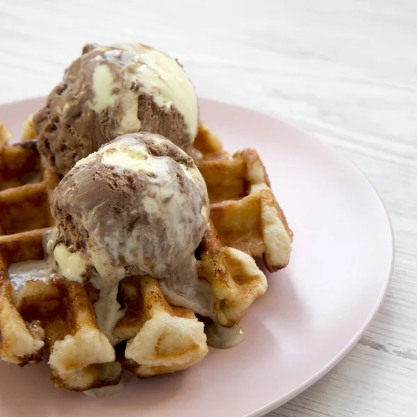 Beyaz ahşap yüzey, yan görünüm üzerinde pembe plaka üzerinde dondurma ile geleneksel Belçika waffle. Yakın çekim. 