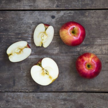 Olgun kırmızı elma ve koyu ahşap yüzey dilimleri. Yukarıdan. Üstten görünüm, düz yatıyordu.