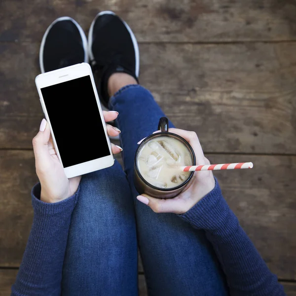 Κορίτσι Που Κάθεται Ένα Ξύλινο Πάτωμα Και Κατέχει Ένα Smartphone — Φωτογραφία Αρχείου