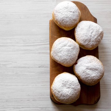 Ev yapımı donut jöle ve beyaz ahşap arka plan, havai görünümü üzerinde rustik ahşap tahta üzerinde pudra şekeri ile. En iyi manzara, yukarıda. Kopya alanı.