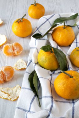 Beyaz ahşap yüzey, yan görünüm üzerinde taze olgun mandalina. Yakın çekim.