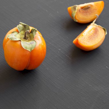 Siyah arka planda, yan görünüm taze Trabzon hurması. Yakın çekim. 