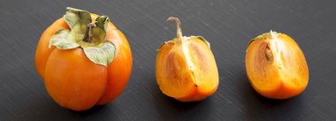 Siyah arka planda, yan görünüm taze Trabzon hurması. Portre. 