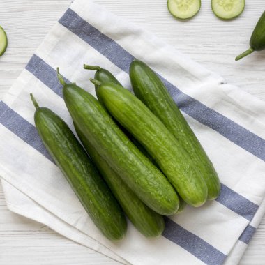 Taze ham organik yeşil salatalık Beyaz ahşap yüzey, havai görünümü üzerinde. Yukarıdan, üstten görünüm düz lay.