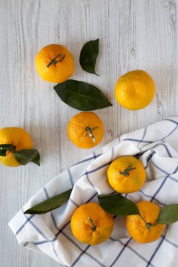 Beyaz ahşap yüzey, en iyi görünüm üzerinde taze olgun mandalina. Yukarıdan, ek yük düz lay. 