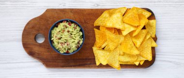 Avokado dip guacamole Nacho Beyaz ahşap arka plan, üstten görünüm üzerinde ahşap tahta üzerinde ile dolu kase.