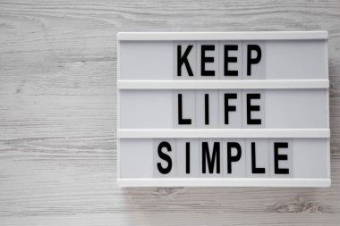 Lightbox ile metin 'Tutmak hayat basit' Beyaz ahşap zemin üzerinde üst görünüm. Yukarıdan Lay, düz. Kopya alanı.