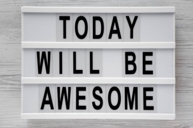 'Bugün harika olacak' kelimeleri modern beyaz ahşap zemin, üstten görünüm üzerinde kurulu. Tepegöz, yukarıdan lay, düz.