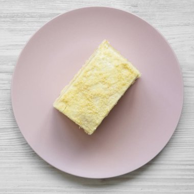 Napoleon kek parçası pembe plaka üzerinde beyaz ahşap yüzey, havai görünümü üzerinde. Yukarıdaki üzerinden düz lay.