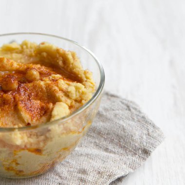 Leblebi, kırmızı biber, zeytin yağı Beyaz ahşap zemin, yan görünüm üzerinde humus kase. Yakın çekim. 