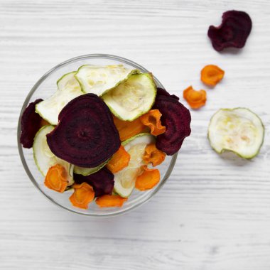 Sebze cips Beyaz ahşap masa, havai görünümü üzerinde tam kase. Yukarıdan, yatıyordu, en iyi görünüm düz. Yakın çekim.