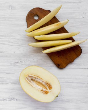 Kavun Beyaz ahşap zemin üzerine dilimlenmiş. Düz lay, ek yükü. Yakın çekim.