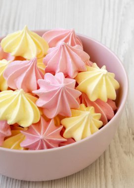 Bir pembe mini meringues Beyaz ahşap yüzey, yan görünüm üzerinde top. Yakın çekim.