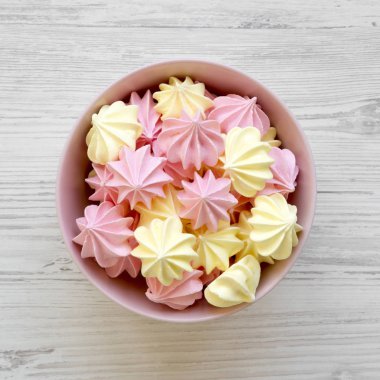 Mini meringues Beyaz ahşap masa, üstten görünüm üzerinde pembe bir kase. Yukarıda, ek yükü.