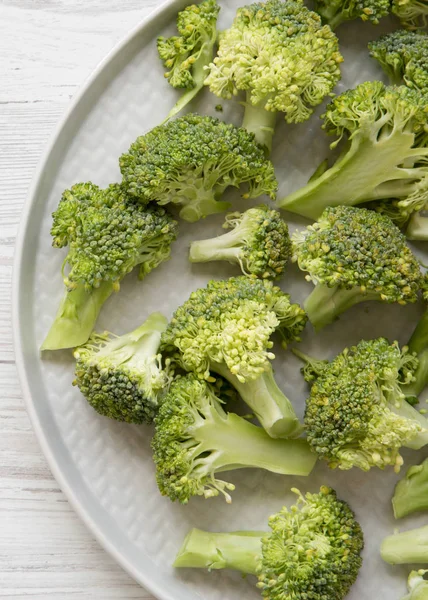Taze Çiğ Brokoli Gri Plaka Üzerinde Beyaz Ahşap Yüzey Iyi — Stok fotoğraf