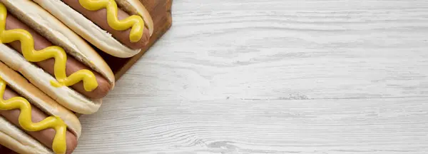 热狗与黄色芥末在木板上的白色木制背景 头顶视图 复制空间 — 图库照片