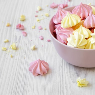 Bir pembe mini meringues Beyaz ahşap yüzey, yan görünüm üzerinde top. Portre.