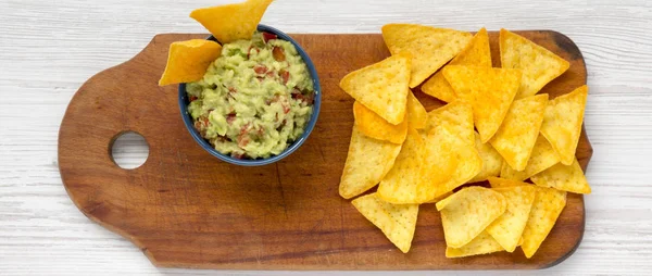 Mısır nachos üzerinde rustik ahşap masa, ek yükü ile geleneksel Meksika guacamole. Üstten görünüm. Yukarıdan. 