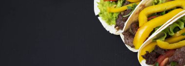 Taco sığır eti ve sebze koyu siyah bir arka plan, yakın çekim. Kopya alanı.