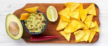 Rustik ahşap tahta üzerinde malzemeler ve mısır nachos ile Geleneksel Meksika guacamole, üst görünümü. Yukarıdan. Düz yatıyordu. 