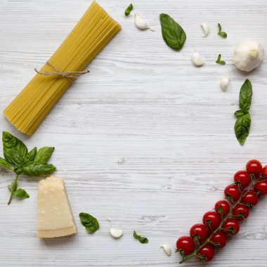 Çerçeve beyaz ahşap zemin, üstten görünüm üzerinde makarna yemek pişirmek için malzemelerle. Düz yatıyordu. Yukarıda, ek yükü.