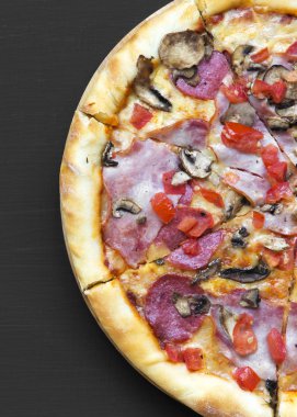 Taze pişmiş pizza siyah yüzey, havai görünümü üzerinde. Yukarıdan, üstten görünüm düz lay.