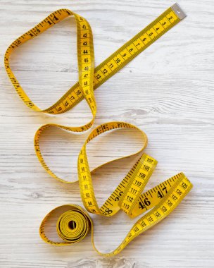 Üstten görünüm, ölçme bant Beyaz ahşap zemin üzerine sarı. Yukarıdan. Boşluk ve metin alanı Kopyala.