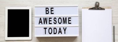 Tablet, pano ve 'bugün harika olacak' word Beyaz ahşap arka plan, üstten görünüm üzerinde modern yönetim kurulu ile çalışma alanı. Yukarıdan, düz-lay, tepegöz. 