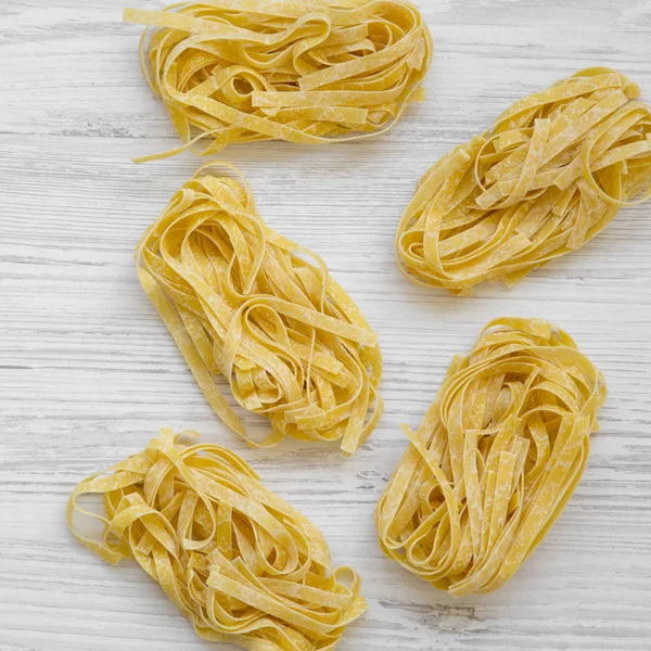 Uncooked Pasta Fettuccine White Wooden Background Top View Overhead Flat — Stock Photo, Image